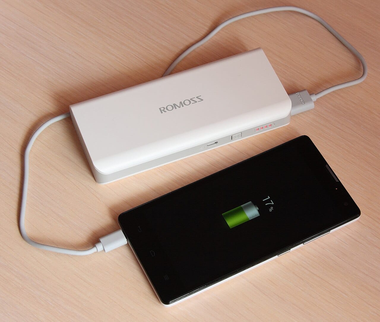 Power bank charging a phone on a desk